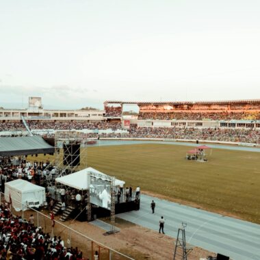 A lively crowd gathers at a football stadium during an outdoor event, showcasing spectator excitement.